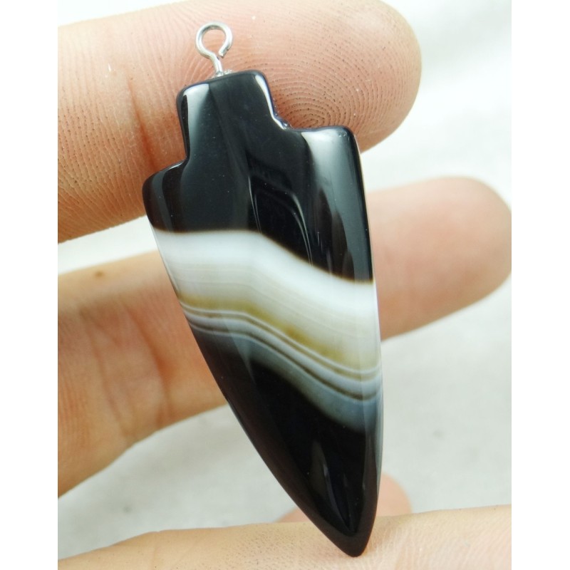 Ce pendentif en forme de flèche, assez spécial, est fin, les couleurs noire et blanche de la pierre font ressortir la forme part