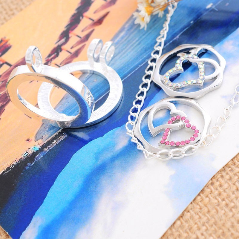 1 médaillon cage, vitré + 2 pièces interchangeables motifs cœurs doubles entrelacés :2 modèles différents / strass roses + str